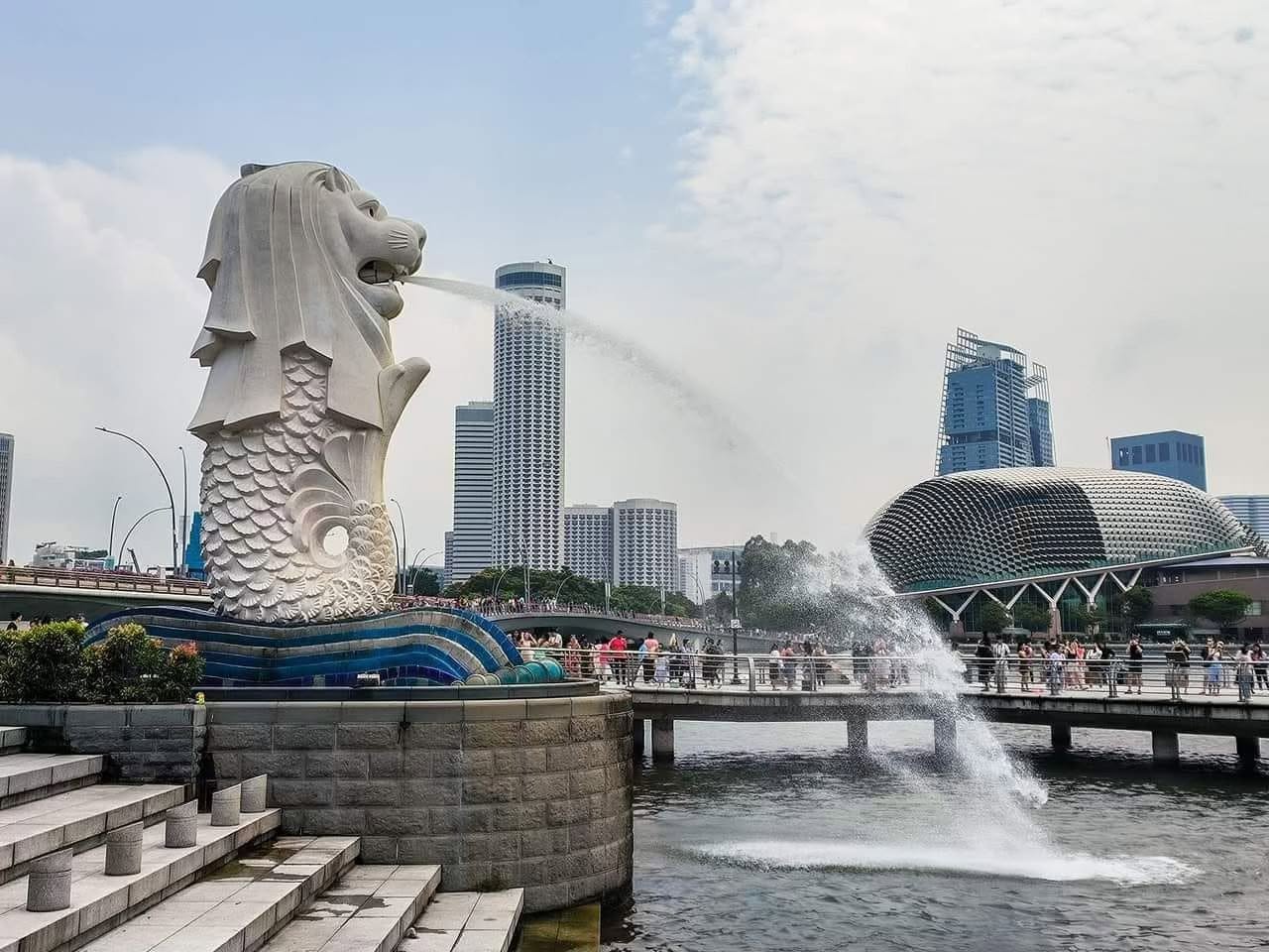 Daytime view of the Merlion statue at Merlion Park with the Esplanade Theatre and city skyline behind it