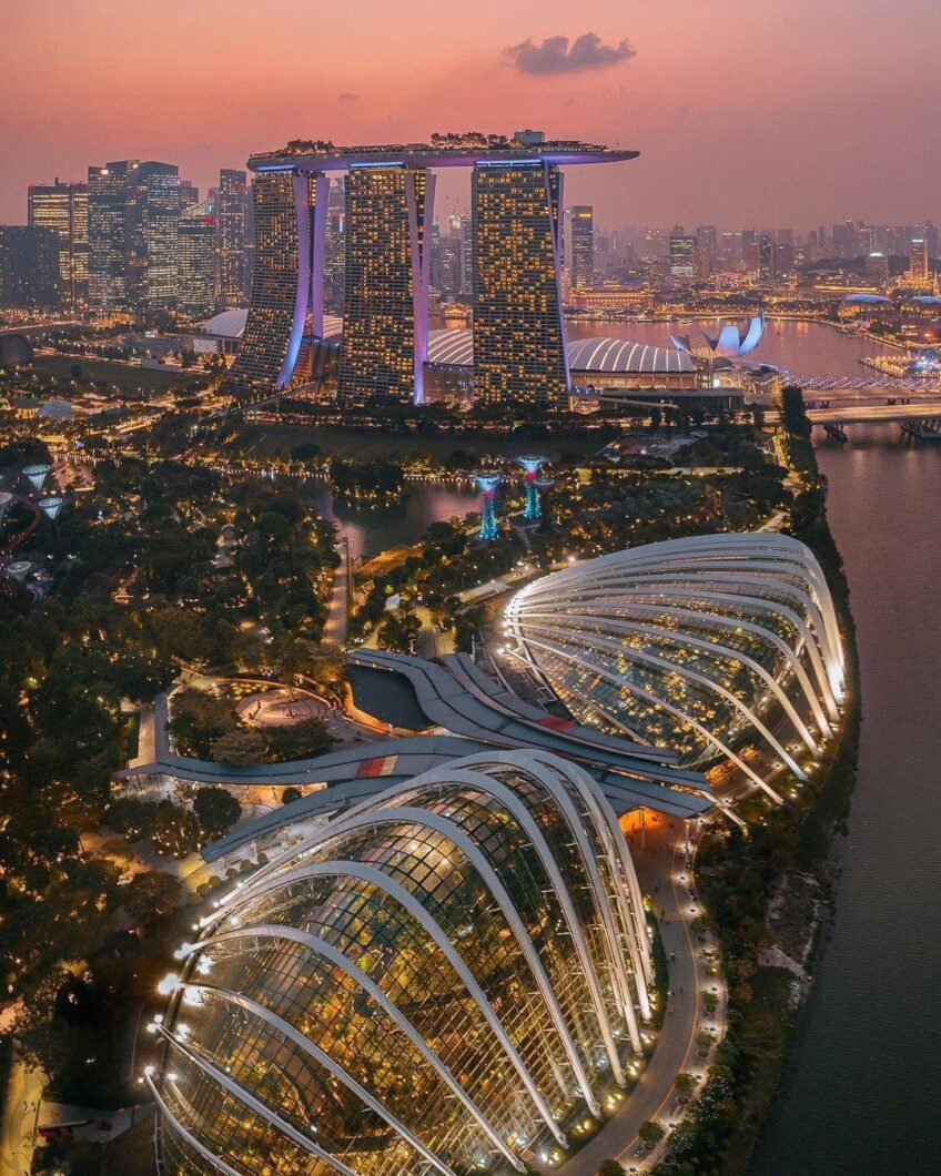 Aerial dusk view of the Flower Dome and Cloud Forest conservatories at Gardens by the Bay with Marina Bay Sands in the distance