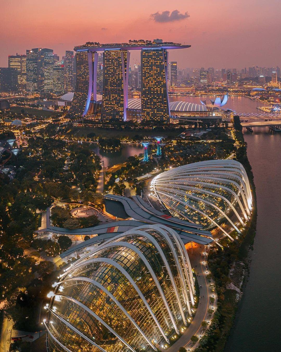 Aerial dusk view of the Flower Dome and Cloud Forest conservatories at Gardens by the Bay with Marina Bay Sands in the distance